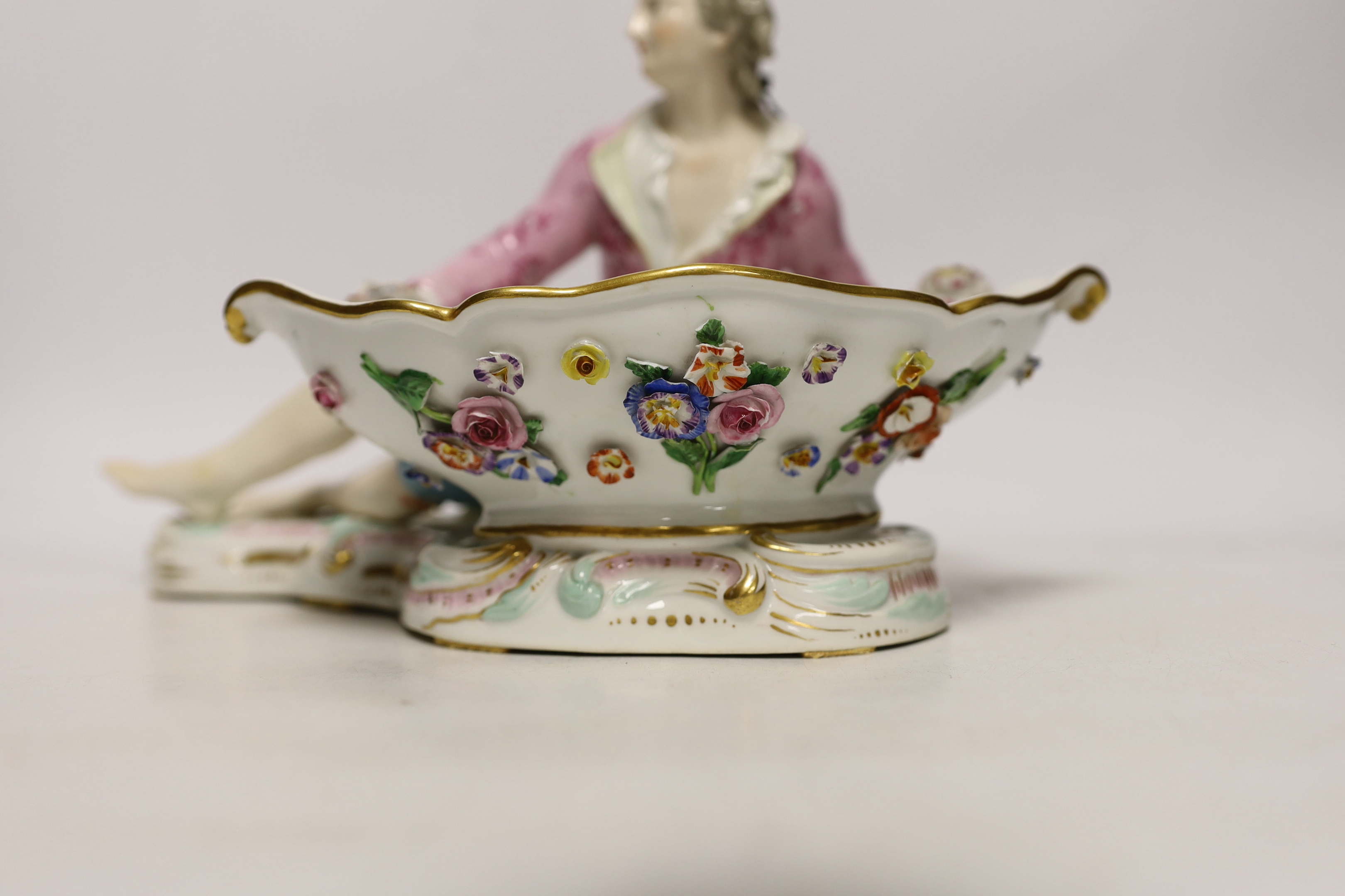 A 19th century Meissen figural sweetmeat dish with floral encrusted decoration, crossed swords mark to the base, 30cm wide